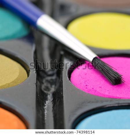 Closeup of a palette of watercolor paints with brush