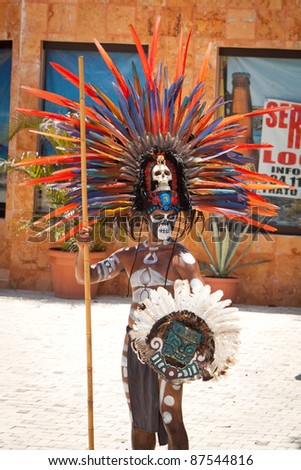TULUM, MEXICO - JULY 15: Unidentified man in Mayan traditional ornamental feather headdress dances to please the rain god Xipe Totec on July 15, 2011 in Tulum, Quintana Roo, Mexico
