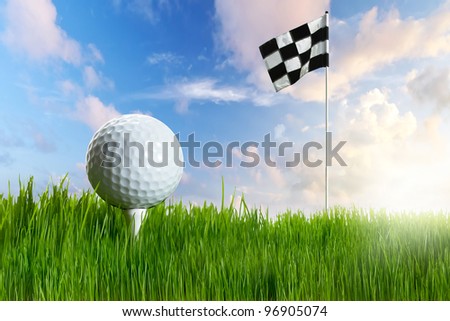 Golf ball with tee in the grass with flag against blue sky
