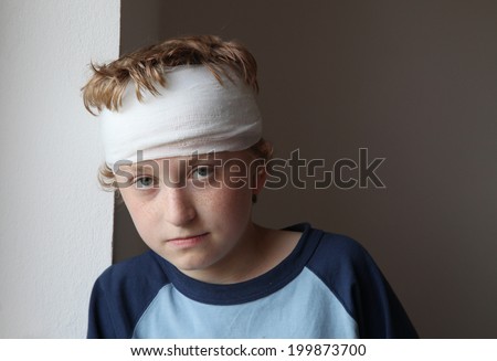 Sad young boy with bandage on his head
