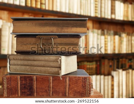 heap of books with book shelf in the background