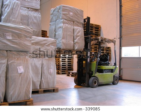 Truck lifting pallet at warehouse