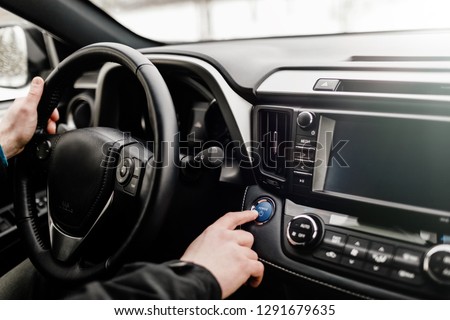 Car driver starting the engine Start, stop engine button.