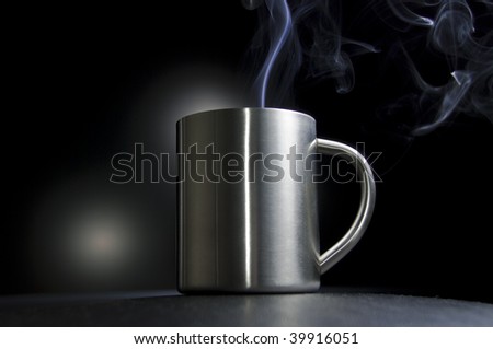 Metal Cup of hot drink color steam over black background