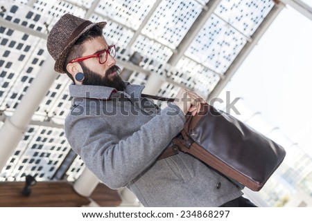 young hipster businessman looking in his shoulder bag