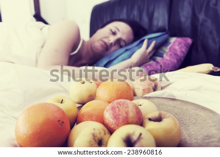 young woman sleeping with fruit in her bed