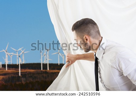 businessman pulls the curtain and discovers wind turbines