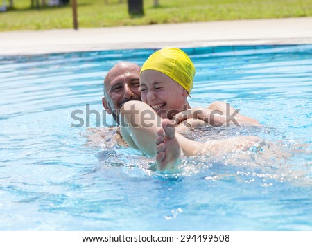 hipster father playing with her daughter in the pool
