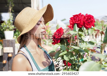 young flower seller takes care of her red roses