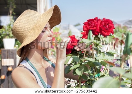 young flower seller takes care of her red roses