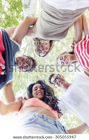 group of smiling friends in circle - bottom view