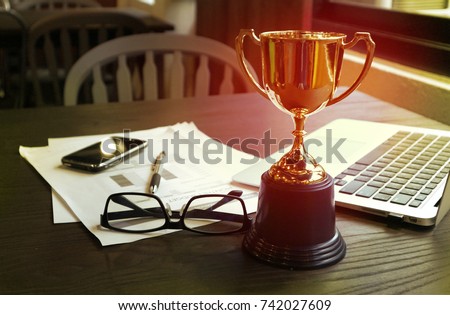 Trophy on work table, win concept