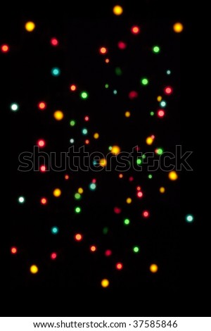An array of different size out of focus fairy lights against a black background, great as a Xmas backdrop.