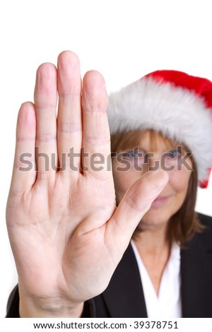 Older senior business woman\'s arthritic hand with knobbly fingers in a stop talk to the hand gesture. Wearing a santa hat.