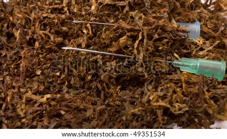 Abstract Smoking Addiction concept of pile of shredded tobacco with hypodermic needle.
