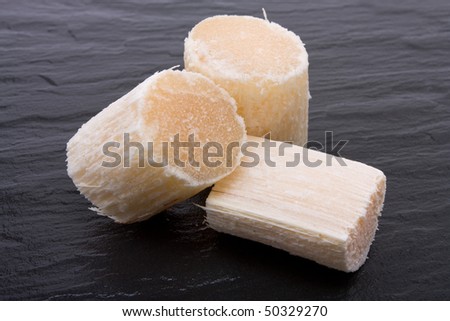 Chunks of Raw Sugar Cane against dark slate background.