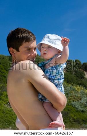 Young Father and 2-3 month old baby son at beach for first time.