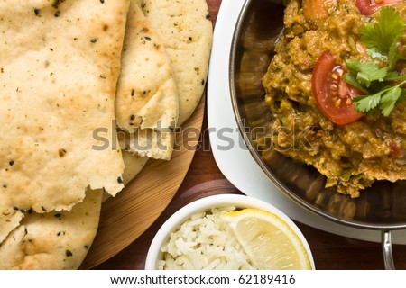 Indian Curry meal of spicy chicken, rice and naan bread.