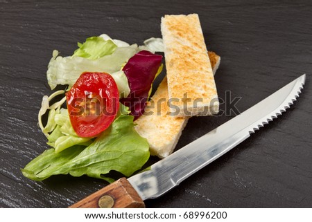 Pate Apetiser with melba toast soldiers and small salad on dark slate background.