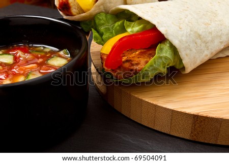 Spicy chicken wrap and pot of vibrant salsa.