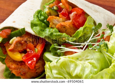 Spicy chicken with salad and salsa wrapped in a soft flour tortilla.