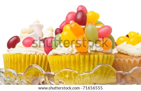 A variety of vibrant fun homemade cup cakes on cake stand.