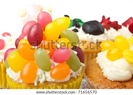 A variety of vibrant fun homemade cup cakes on cake stand.