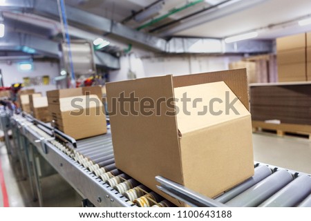 Cardboard boxes on conveyor belt. Board, package.