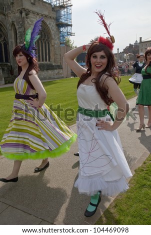 EXETER - MAY 18: Performers in frilly dresses on Exeter Cathedral Green as part of the Battle for the Winds Parade on May 18, 2012 in Exeter, UK