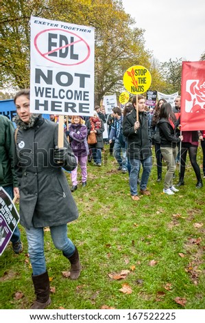 EXETER - NOVEMBER 16: A lady holds up a \'EDL Not Welcome Here\', with a stop the Nazis sign behind her during the Exeter Together march and diversity festival on November 16, 2013 in Exeter, Devon, UK