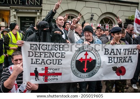 EXETER, UK - NOVEMBER 16: English Defence League supporters hold up a banner during the English Defence League march and rally November 16, 2013 in Exeter, Devon, UK