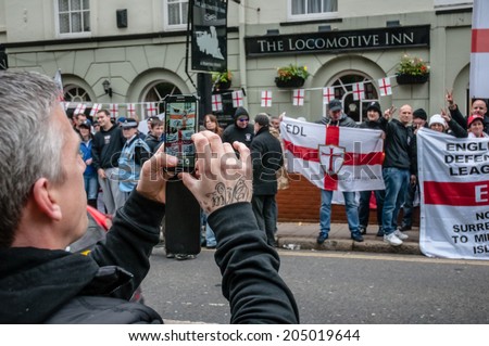 EXETER, UK - NOVEMBER 16: A man taking pictures of English Defence League supporters during the English Defence League march and rally November 16, 2013 in Exeter, Devon, UK