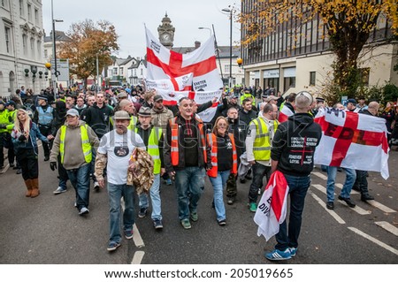 EXETER, UK - NOVEMBER 16: English Defence League members march along the street during the English Defence League march and rally November 16, 2013 in Exeter, Devon, UK