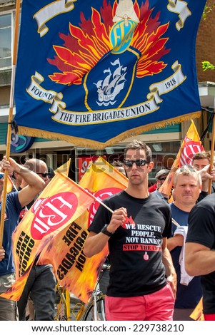EXETER - JULY 10: Fire Brigade Union member walks along Exeter High Street during the public sector workers national day of action in Exeter City Centre on July 10,  2014 in Exeter, Devon, UK