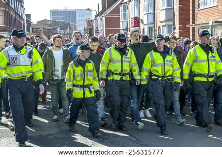 EXETER, ENGLAND - FEBRUARY 21, 2015: Devon and Cornwall Police escort Plymouth Argyle FC football fans at the League 2 football match between Exeter City FC and Plymouth Argyle FC