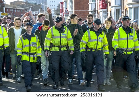EXETER, ENGLAND - FEBRUARY 21, 2015: Devon and Cornwall Police escort Plymouth football fans  during the police operation at the League 2 football match between Exeter City FC and Plymouth Argyle FC