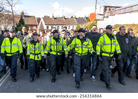 EXETER, ENGLAND - FEBRUARY 21, 2015: Devon & Cornwall Police escort Plymouth Argyle football fans along St James\'s Road during the League 2 football match between Exeter City FC and Plymouth Argyle FC