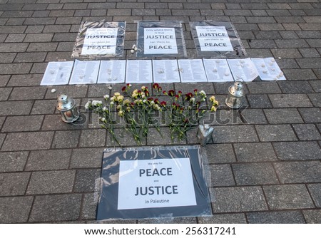 EXETER, ENGLAND - JULY 15, 2014: Peace signs, flowers and lists of Palestinians who have been killed by the Israeli army during the Peace Vigil for Gaza in Exeter's Princesshay Square.