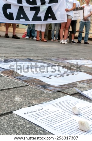 EXETER, ENGLAND - JULY 15, 2014: List of the Palestinians who have been killed by the Israeli army, with a Gaza banner in the background during the Peace Vigil for Gaza in Exeter\'s Princesshay Square.