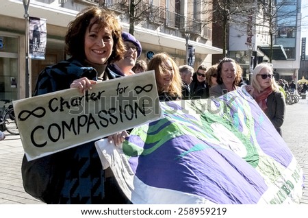 EXETER, ENGLAND - MARCH 7, 2015: Devon United Women hold a banner during the Walk for Peace through the city of Exeter to celebrate International Women\'s Day.