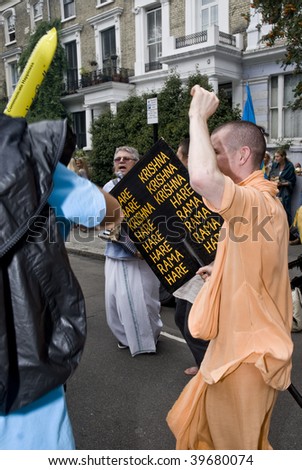 NOTTING HILL, LONDON - AUG 31: Devotees from Hare Krishna dancing with carnival revelers in Westbourne Park Road at Notting Hill carnivalon August 31 2009 in London, UK.