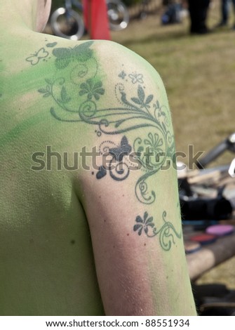 EXETER - JUNE 11:A tattoo on a shoulder of a painted body at the first ever Exeter Naked Bike Ride, a fun protest that highlighted non-oil dependent modes of transport on June 11, 2011 in Exeter