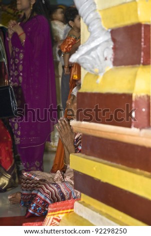 TORONTO - JUNE 19: An older female HIndu devotee sits on the floor and prays during the chariot festival at the Richmond Hill Hindu Temple on June 19, 2009 in Toronto,