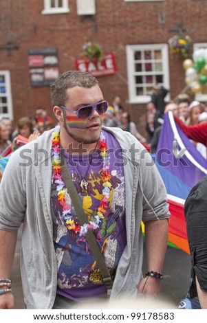 EXETER - MARCH 31: Festival goers with painted faces hold the rainbow banner at the Exeter Pride 2012 Parade in Exeter City centre  on March 31, 2012 in Exeter, UK
