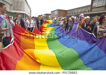 EXETER - MARCH 31: Festival goers hold the rainbow banner at the Exeter Pride 2012 Parade in Exeter City centre on March 31, 2012 in Exeter, UK
