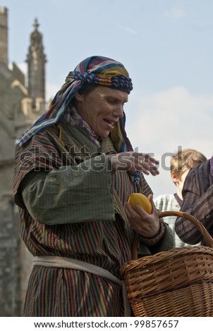 EXETER - APRIL 6: Actors offer the audience fruit during the Good Friday Walk of Witness on Exeter Cathedral Green on April 6, 2012 in Exeter, UK