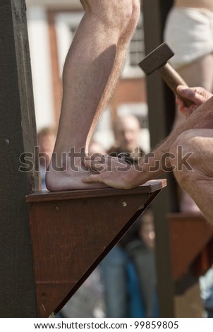 EXETER - APRIL 6: Jesus\'s feet are nailed to the cross as part of the  during the Good Friday Walk of Witness in Exeter City Centre on April 6, 2012 in Exeter, UK