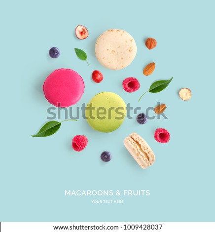 Creative layout made of macaroons, raspberry, blueberry and nuts . Flat lay. Food concept. Abstract background.