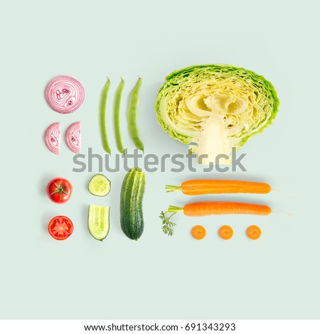 Creative layout made of cucumber, carrot, tomato, onion and cabbage and green beens. Flat lay. Food concept.