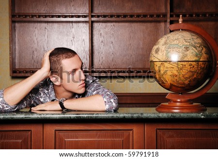 young sad handsome man at  bar counter looking at the globe